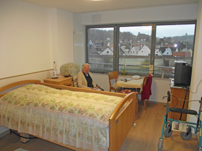 Alte Frau in ihrem Zimmer im Seniorenheim