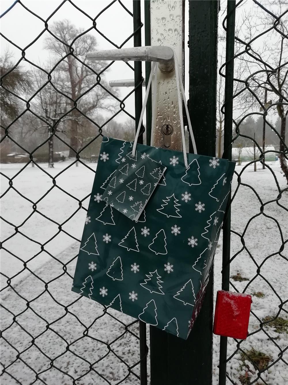 Eine Weihnachtstüte hängt an einer Türklinke