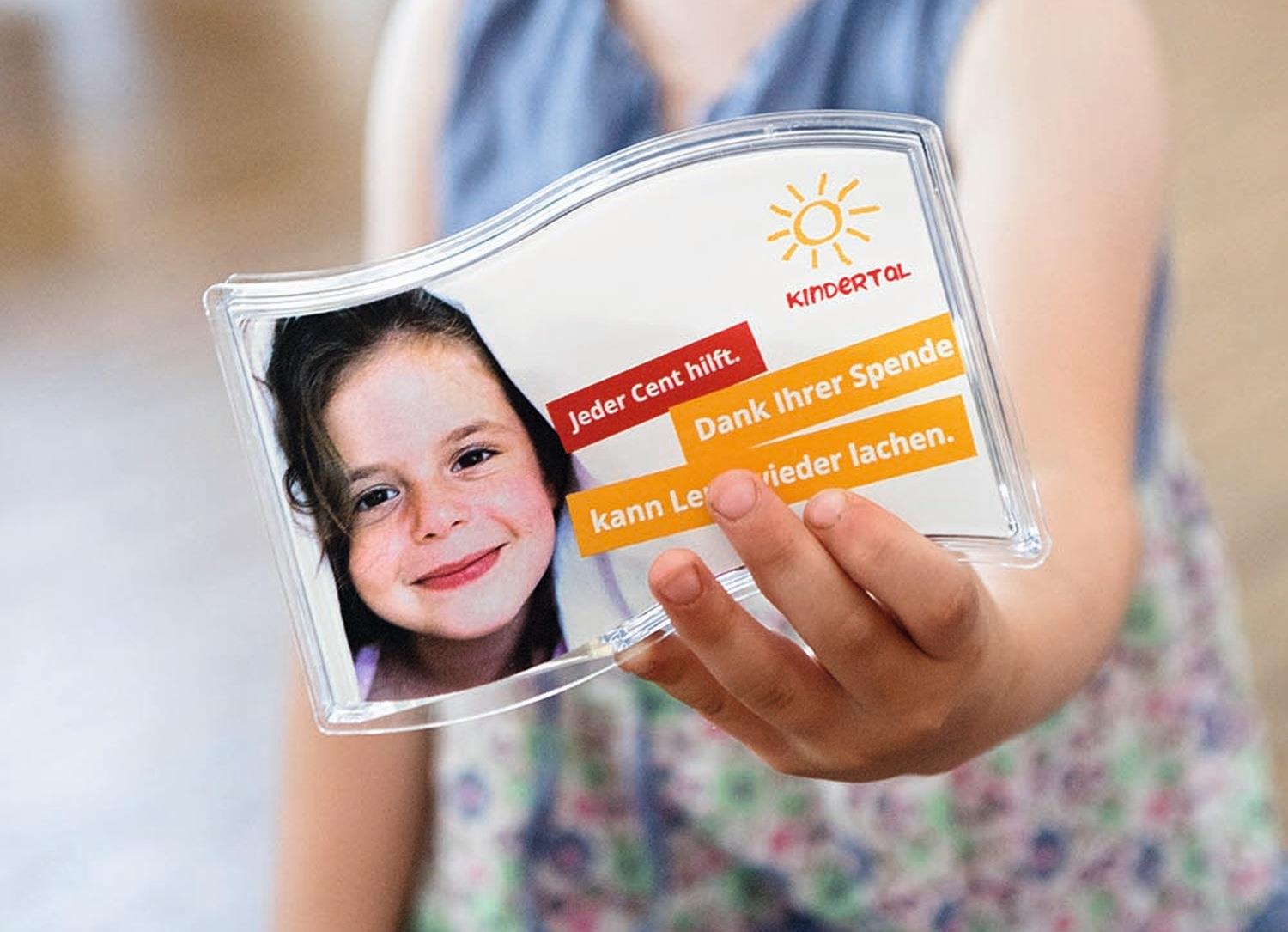 Eine Kinderhand streckt die Spendendose des Vereins Kindertal vor.