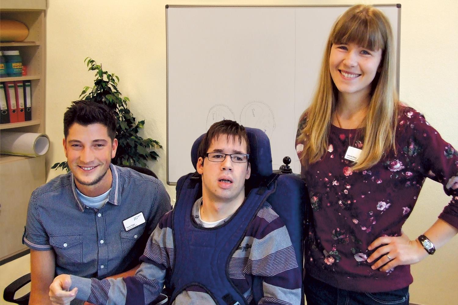 Zwei Betreuer mit jungem Mann mit Behinderung