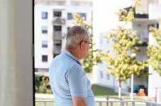 Ein Mann um die Sechzig blickt auf neue Wohnhochhäuser.