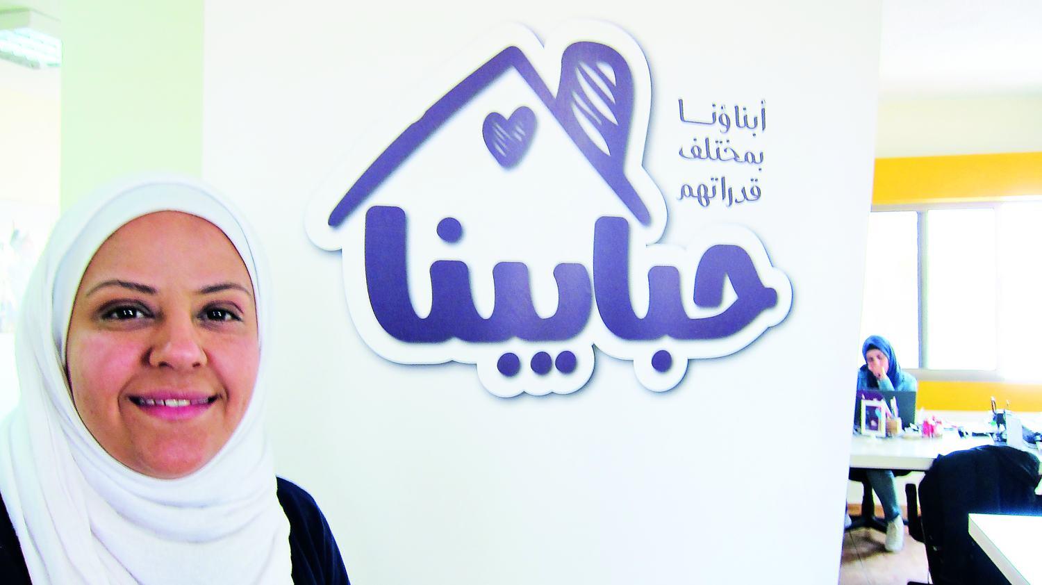 Reem vor dem Logo ihrer Website Habaybna.net