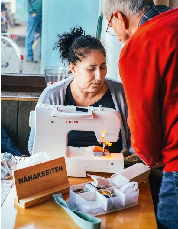 Eine ehrenamtliche Mitarbeiterin des Repair-Cafés an der Nähmaschine.