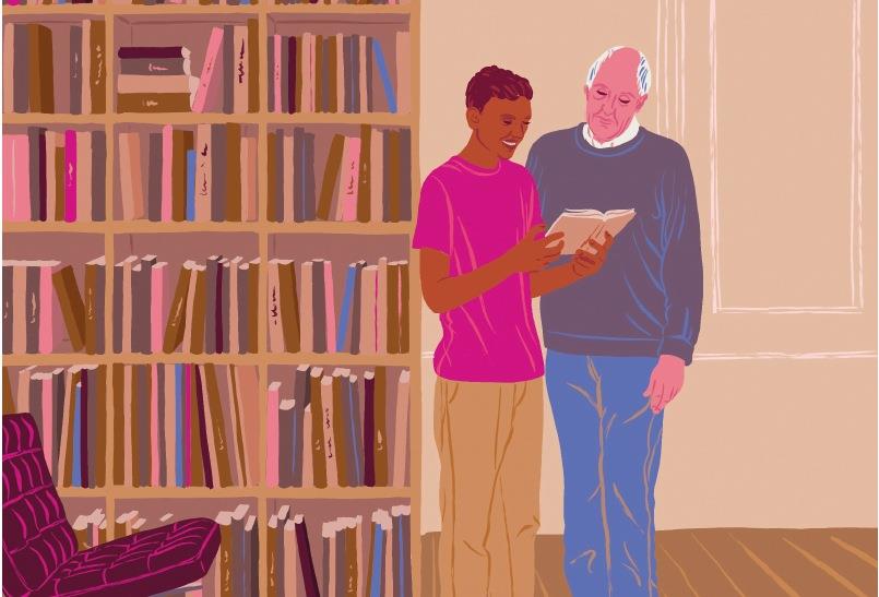 Der Ehrenamtliche und sein Schützling an einem großen Bücherregal.