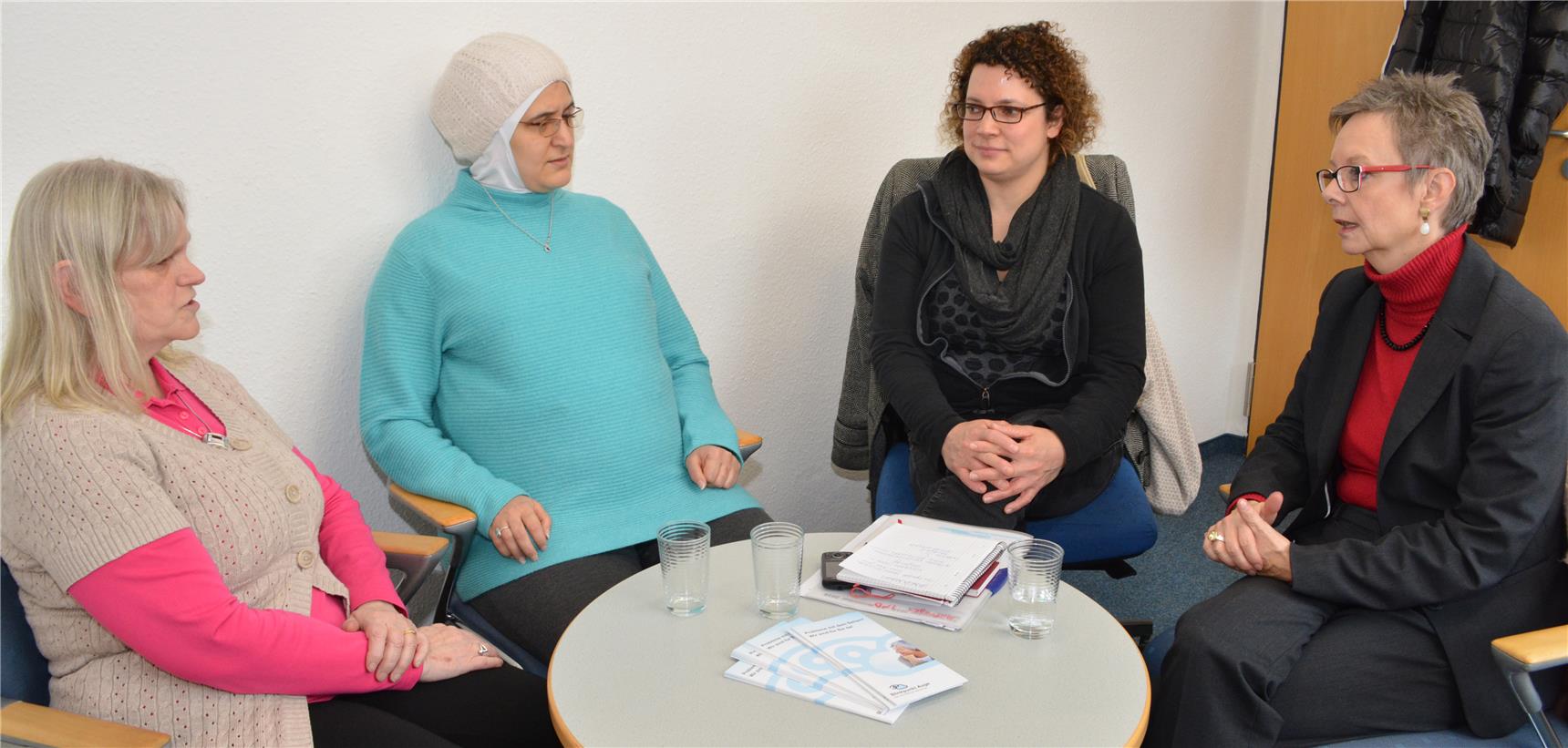 Vier Frauen sitzen an einem runden Tisch