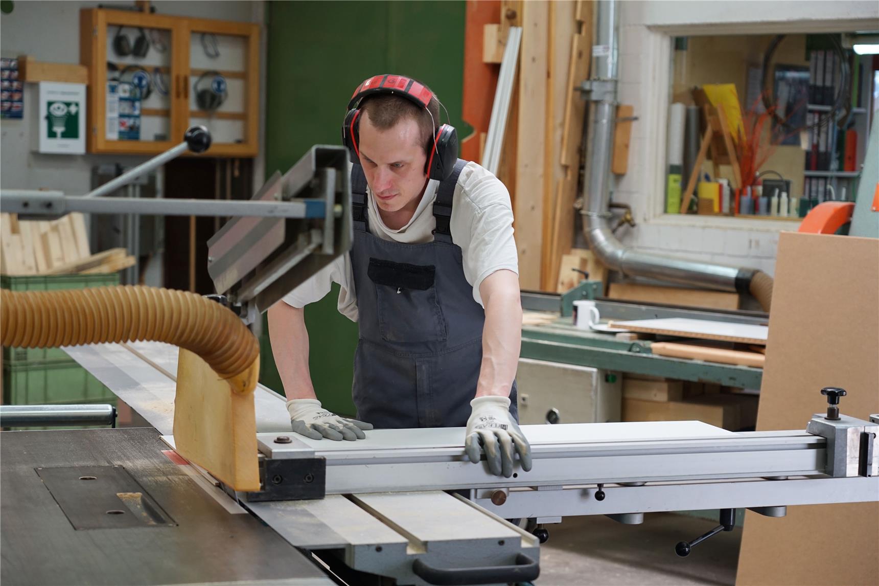 David Dupke sägt in der Schreinerei der St. Laurentius-Werkstätte in Hagen Holzfaserplatten für Trennwände zurecht. 