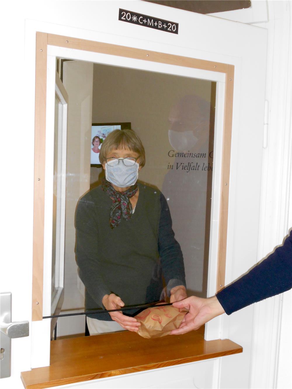 Ehrenamtliche Mitarbeiterin bei der Brotausgabe an der Pforte