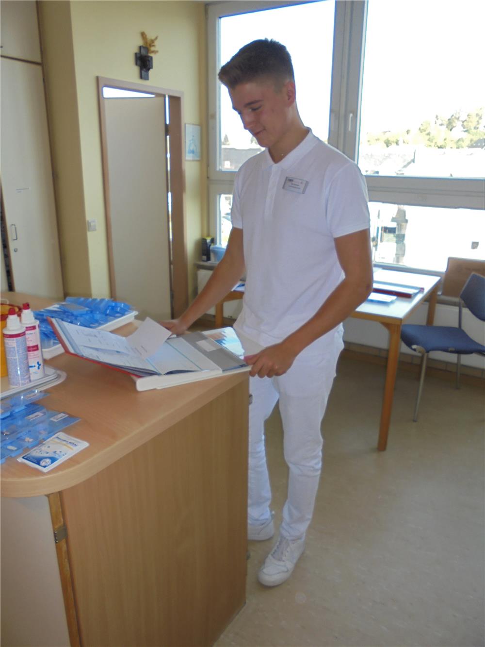 Pflegeschüler Eric Dauster schaut Unterlagen am Computer durch.