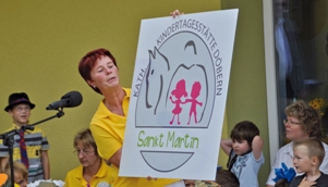 Kita-Leiterin mit dem neuen Logo der Einrichtung