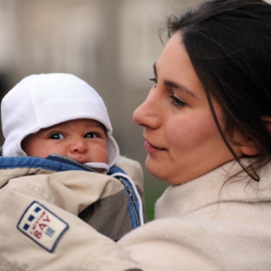 Eine Mutter mit ihrem Kind auf dem Arm.