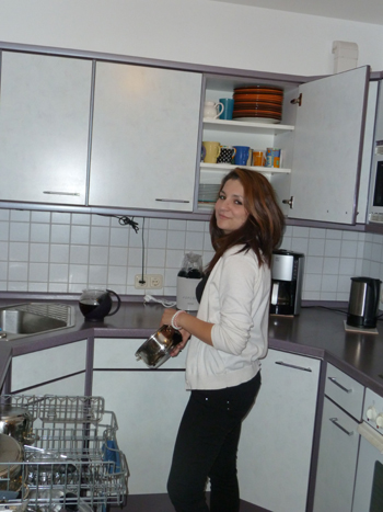 Wir blicken in eine helle Wohnküche. Links unten sind einzelne Etagen des Geschirrspülers ausgefahre