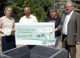 Georg Hattel, Henkel-Mitarbeiter, übergibt den symbolischen Scheck an die Sankt-Florian-Stiftung.