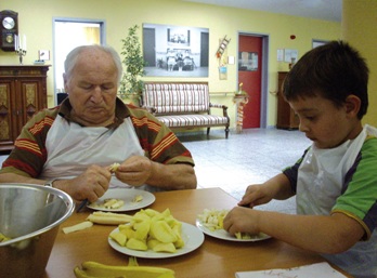 Senioren und Kinder im Burjanheim beim Obstschneiden