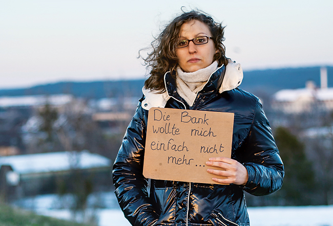 Junge Frau hält einen Karton mit der Aufschrift 