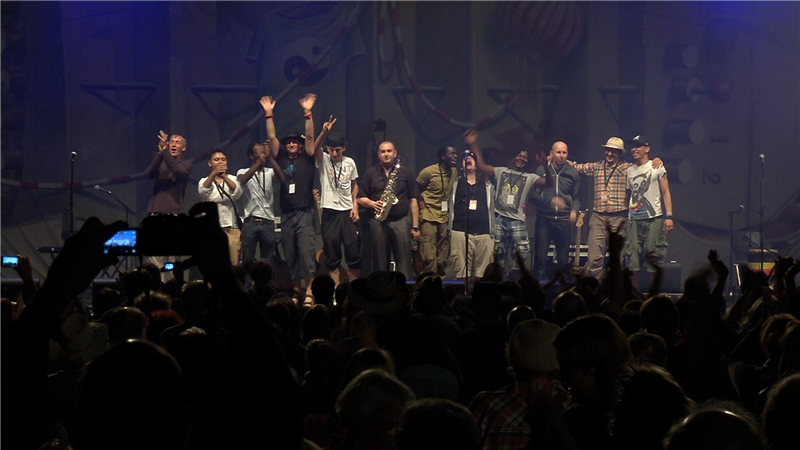 Auf dem Foto sind die Band Strom & Wasser und die Refugees auf der Bühne bei einem umjubelten Auftritt zu sehen