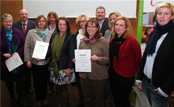 Auf dem Foto steht ein Gruppe von Menschen mit den Förderzusagen in der Hand