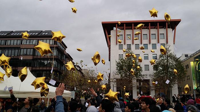 Eine Menschenmenge auf dem Uniplatz in Fulda hat goldene Sternenballons in den Himmel fliegen lassen.
