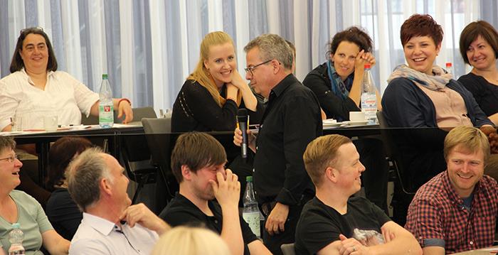 Herr Bosch geht durch die Reihen und spricht in ein Mikro. 